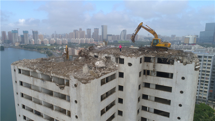 海南?？?挖掘機“爬上”22層高樓作業，城市更新中的綠色拆除新篇